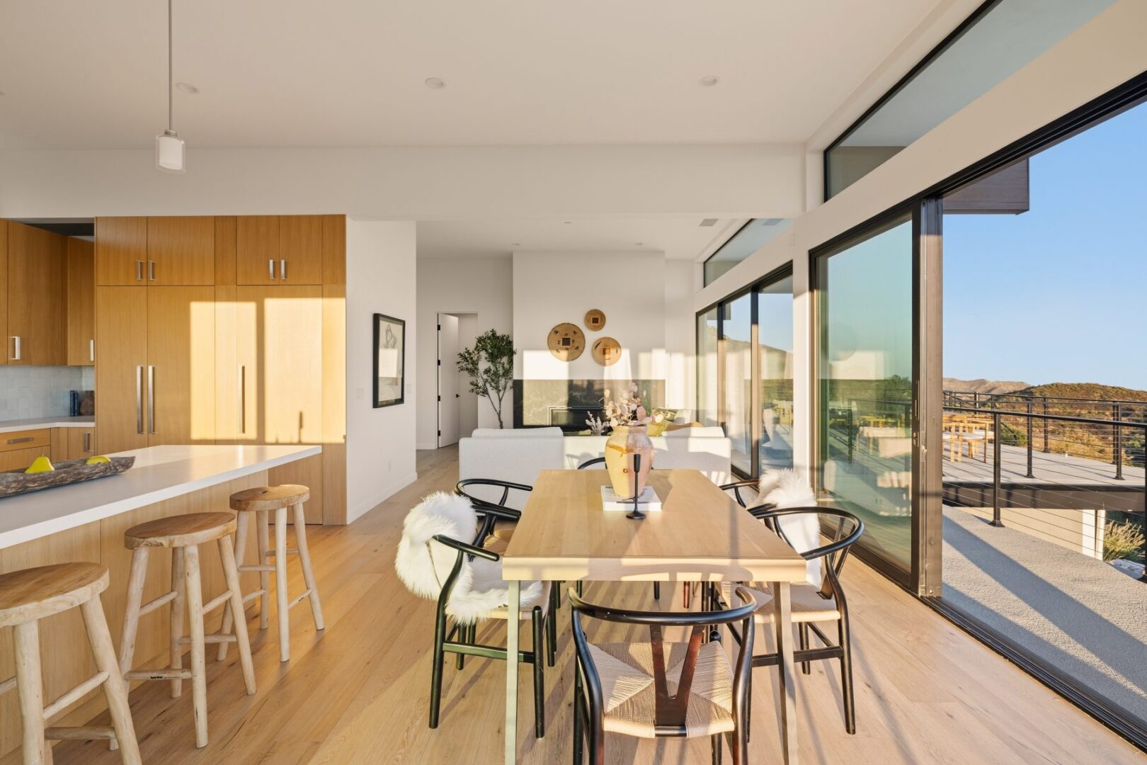 Dining area with wooden table and large windows letting in natural light.