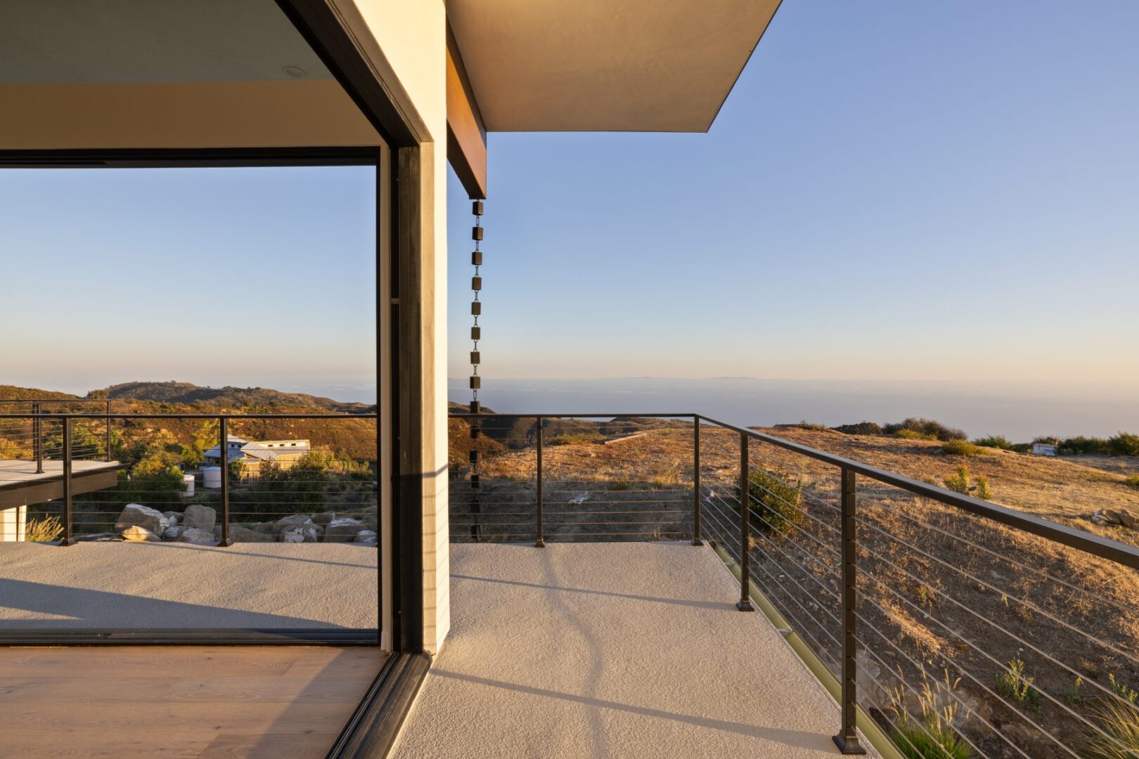 Balcony view with a modern design and mountain backdrop.