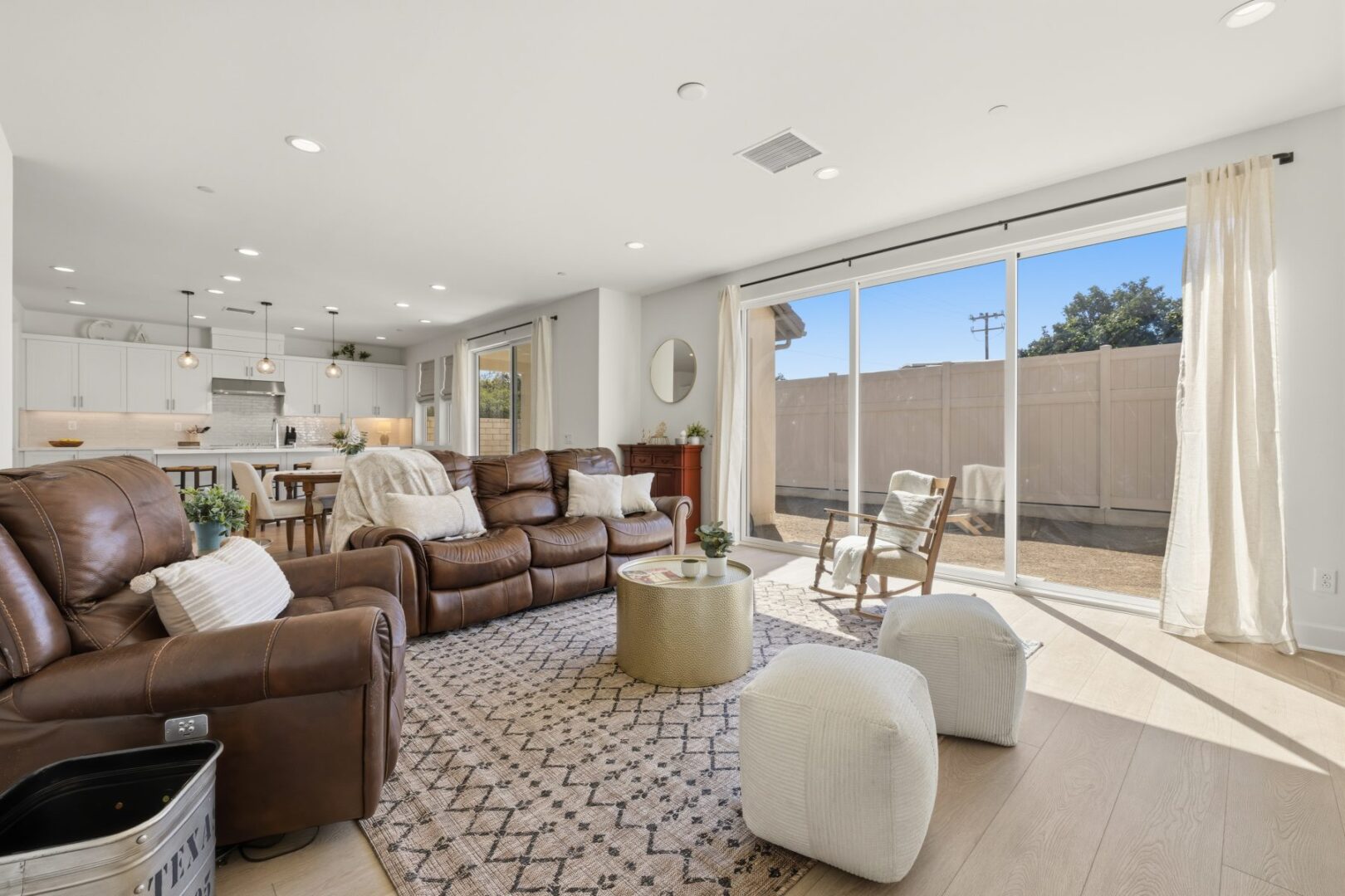 Living room opens to the kitchen and dining area, with sliding doors facing the fenced yard.